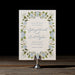 Roydon  save the date card with floral design on a stand against a dark background