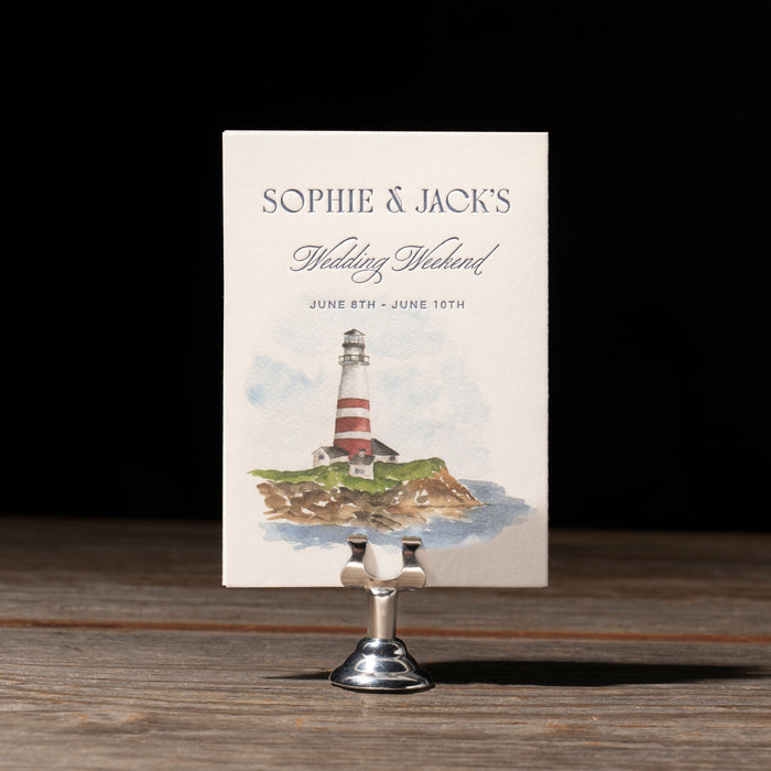 Ryann v2 wedding events card with lighthouse design on a stand against a dark background