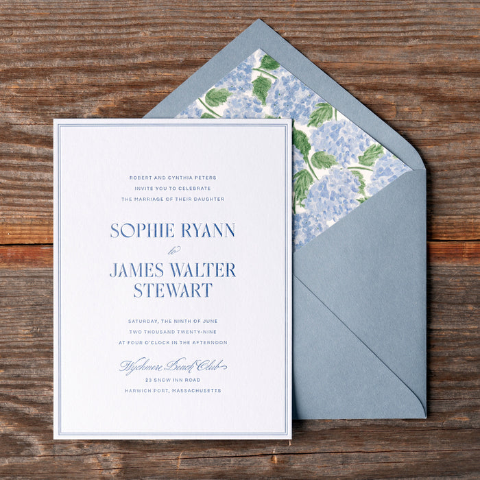 Ryann v2 wedding invitation with floral liner on a wooden surface