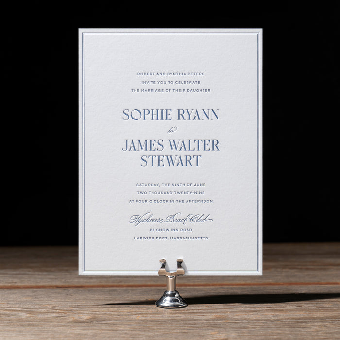Ryann v2 wedding invitation card on a stand with a dark background