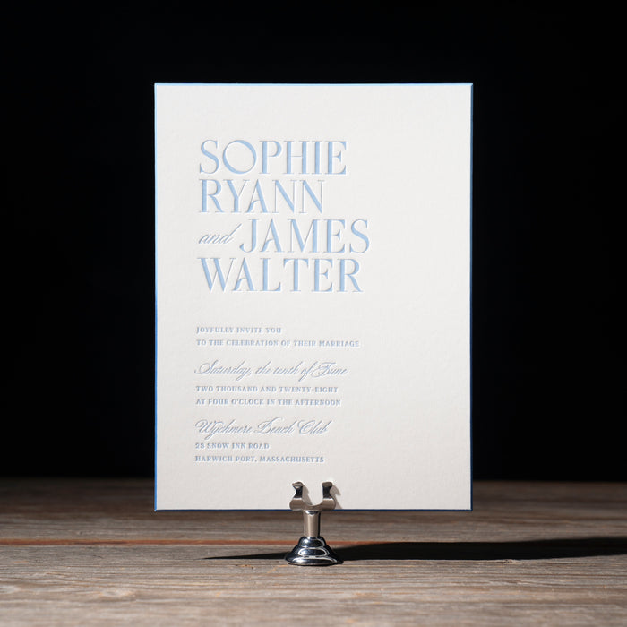 Ryann wedding invitation card on a stand with a black background