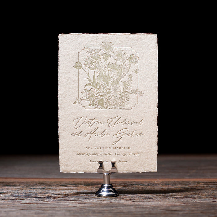 Vintage-style save the date on a stand with a dark background