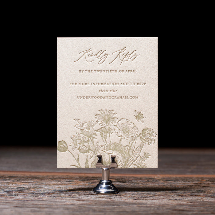 Invitation card with floral design on a  stand against a dark background