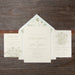 Set of wedding invitations with floral designs on a wooden surface