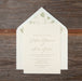 Wedding invitation card with floral design on wooden surface