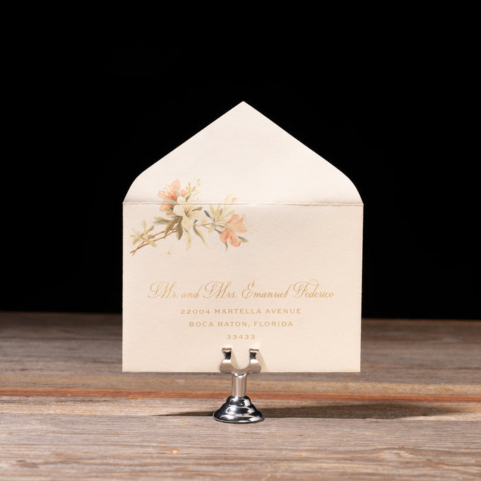 Decorative reply envelope with floral design and text on a wooden surface